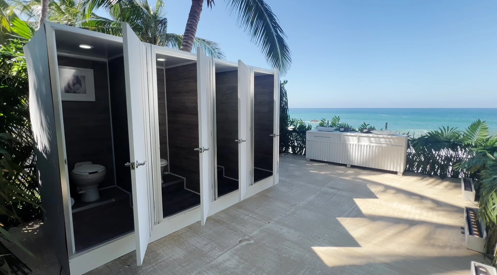 Luxury VIP portable toilets by the sea with palm trees and premium sinks for an exclusive event — Luvory